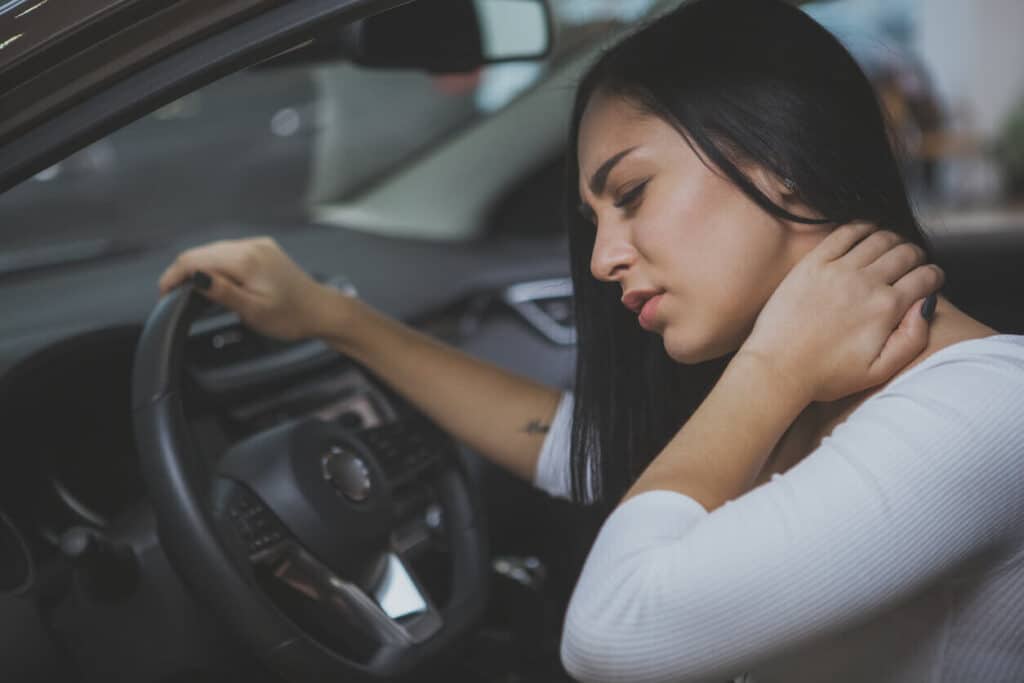Woman rubbing her neck after a car accident.