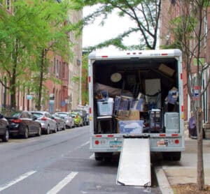 Moving truck filled with household items parked in a street.