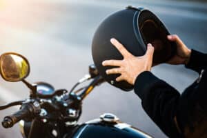 motorcyclist putting on helmet