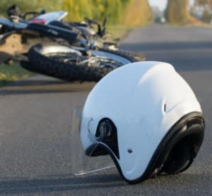 Motorcycle helmet on the street behind motorcycle accident.