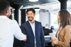 Smiling businessman shaking hands with female professional.