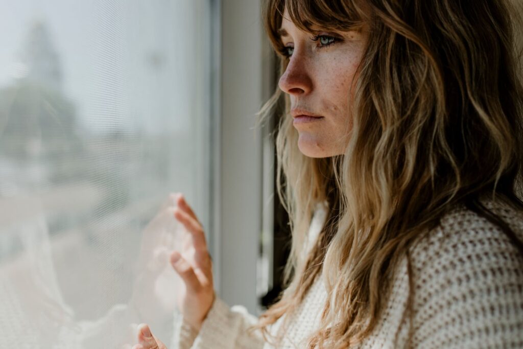 woman looking longingly out a window