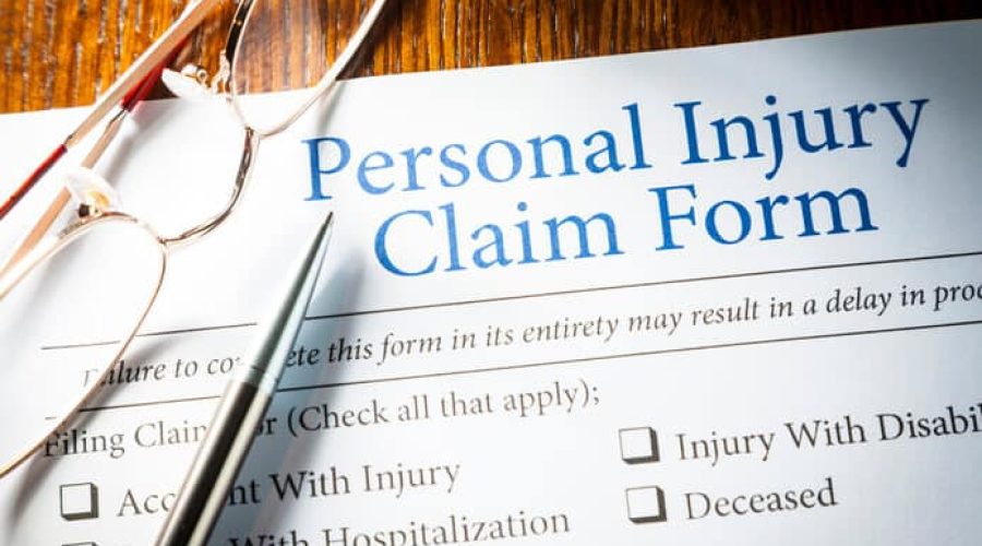 Personal Injury Claim form with pen and glasses